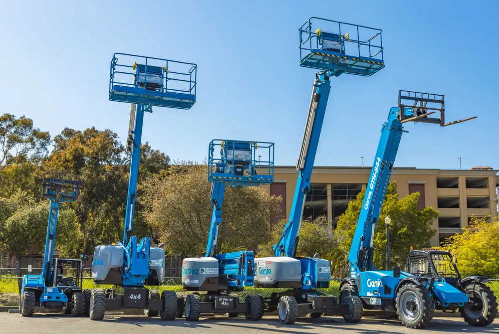 Blue aerial work platforms and lift equipment at an industrial site