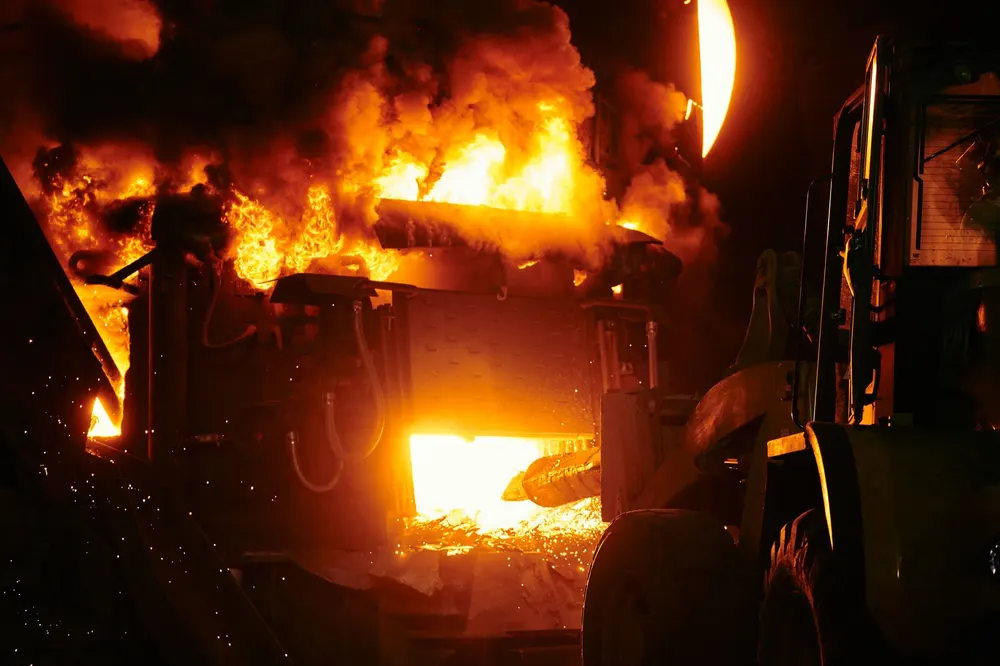 Industrial furnace with intense process flames and heavy machinery