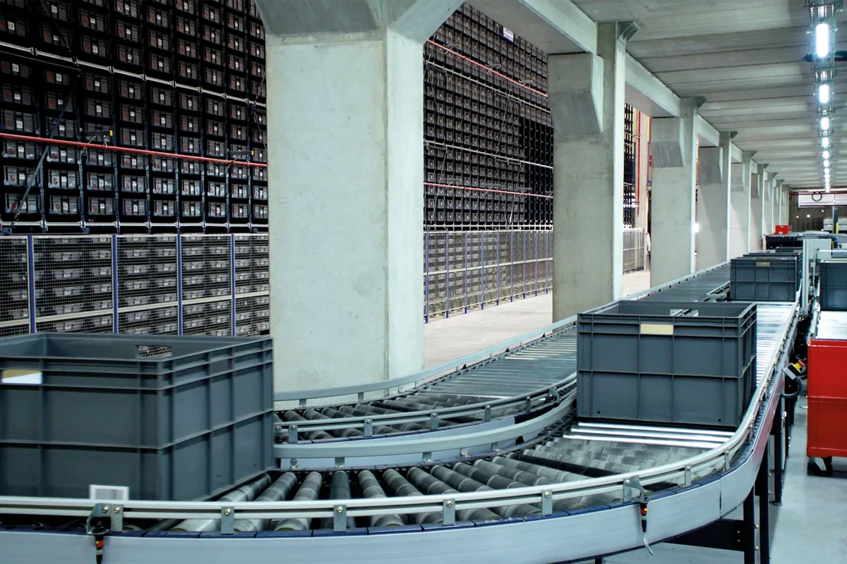 Automated storage and retrieval system with high-density tote storage feeding a conveyor line